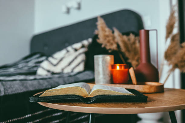 istock Open bible on wooden table in bedroom, scandinavian interior 1432300395