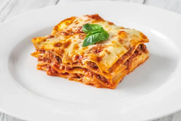 Portion of traditional italian lasagne on white plate