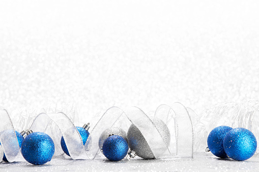 Beautiful Glitter christmas balls and ribbon close-up on shining background