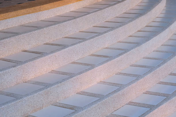 Curve line pattern of exposed aggregate finish cobblestone with white tile floor of vintage staircase