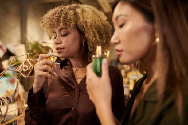 mulheres cheirando perfume na loja - asian ethnicity women shopping mall perfume - fotografias e filmes do acervo