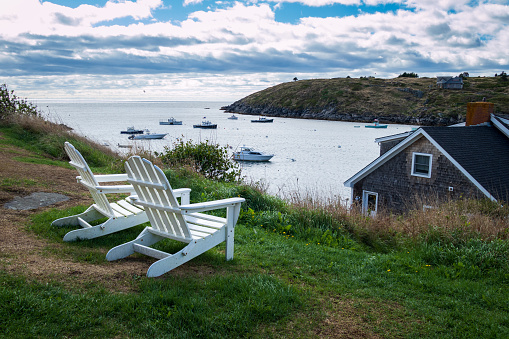 Two  Adirondack chairs overlooking the harbor on Monhegan Island, Maine