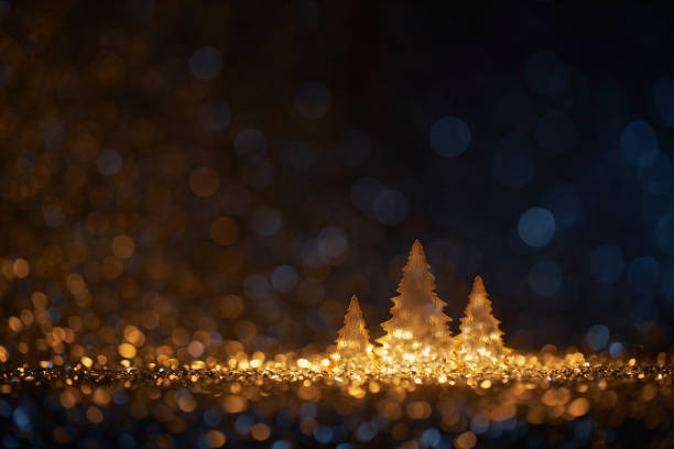 Abstract golden Christmas trees on defocused gold and blue lights -Decoration Bokeh stock photo