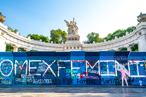 Mexico, Mexico City - June 4, 2022: The Benito Juárez Hemicycle is a monument located at Alameda Central, the statue of Juárez is made with marble, with feminist graffiti against violence in the city.