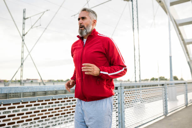 istock One man, senior male jogging on the sidewalk in sunset. 1432311710