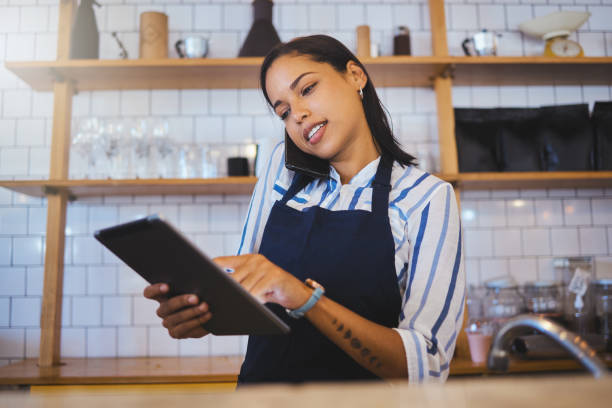 istock Cafe manager, planning online customer orders and working on digital tablet with internet, phone call and sales in restaurant startup. Small business owner, woman entrepreneur and hospitality worker 1432312923