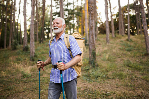 istock Senior man using hiking poles on a hike 1432319190