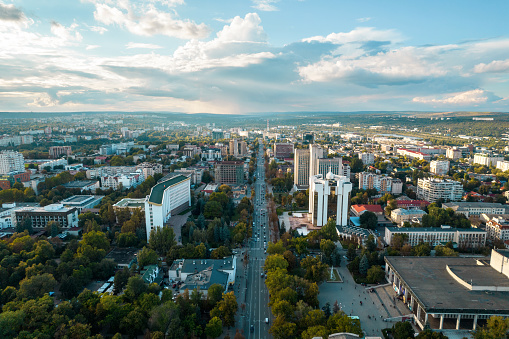 Aerial drone view of Chisinau at sunset, Moldova. View of city centre with presidency and parliament, multiple buildings, roads, lush greenery