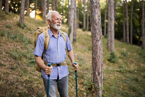 istock Senior man using hiking poles on a hike 1432320360
