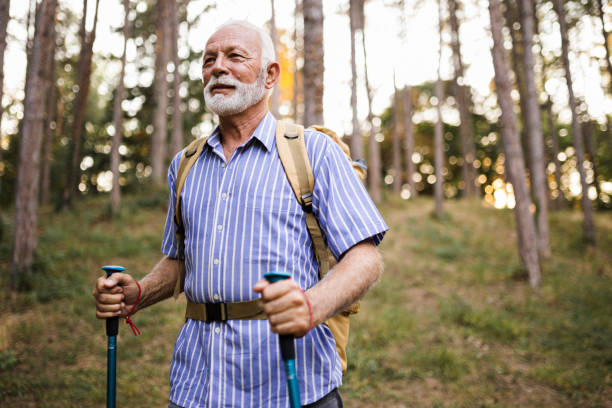 istock Senior man using hiking poles on a hike 1432320385