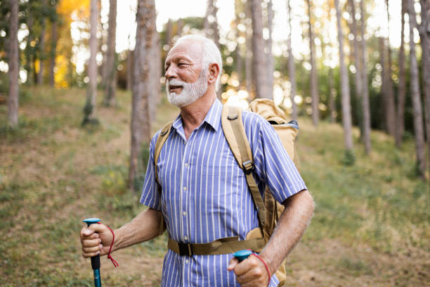 istock Senior man using hiking poles on a hike 1432320805