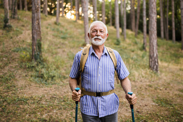 istock Senior man using hiking poles on a hike 1432320889