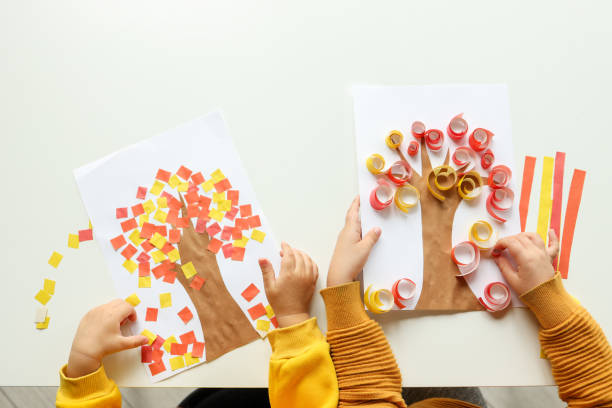 los niños hacen una aplicación, vista superior, manos de cerca. clase magistral de otoño - craft project fotografías e imágenes de stock