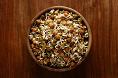 Close-up of A mix of organic sprout seeds sprouting ( germinating) bowl contains almond, groundnut, black gram, wheet, fenugreek and mung beens,  in bowl in the studio