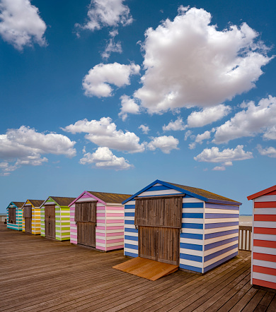 Hastings pier with colorful striped huts resort town in East Sussex England UK United Kingdom