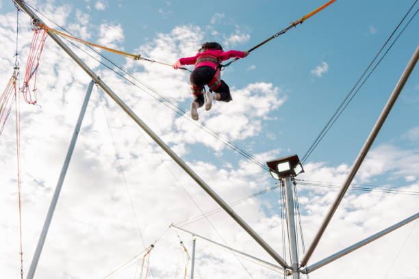 istock Girl is jumping on a bungee trampoline 1432330127