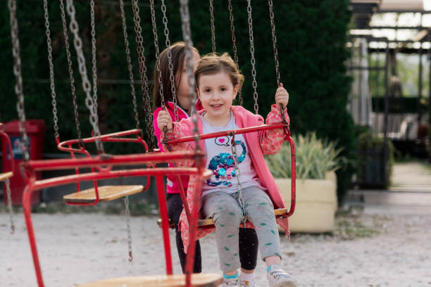 istock Happy kids having fun on chain swing ride 1432330202