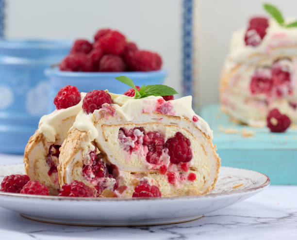 istock Baked meringue roll with cream and fresh red raspberry, white background 1432336998