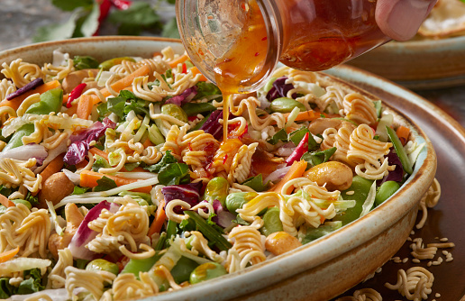 Crunchy Ramen Asian Salad with Toasted Ramen Noodles, Cabbage, Carrots, Cucumbers, red Chili's, Cashews, Snap peas and a Sweet Chili Vinaigrette Dressing