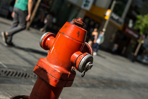 Red fire hydrant on the street for emergency fire access, with key, after use.