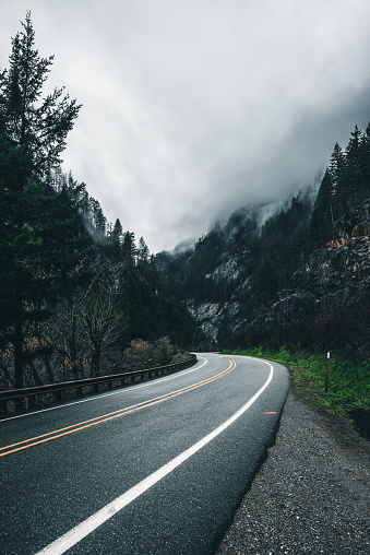 A slick windy road under a dramatic sky in the Pacific Northwest's Cascade Mountain Range.