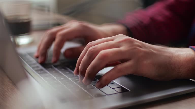 Close up of freelancer's developer hands typing program code on laptop keyboard in coworking. Businessman at work in working in office. Copywriter writing text on computer keyboard in coffeeshop.