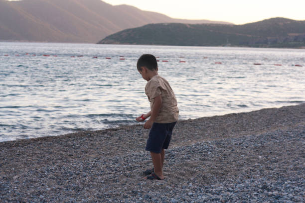 istock A young boy throws a stone as hard as he can into the sea on his summer holiday. 1432343580