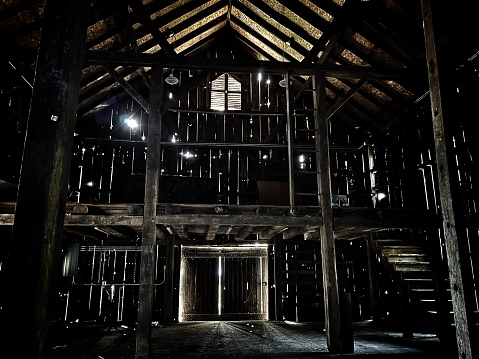 Dark wood barn interior with lights beaming in from outside