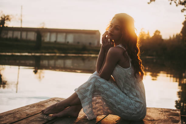 A beautiful woman is sitting by the river