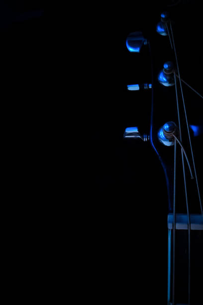istock Guitar fretboard on a black background close-up 1432348903