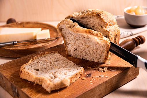 Fresh rectangular bread sliced on a wooden board