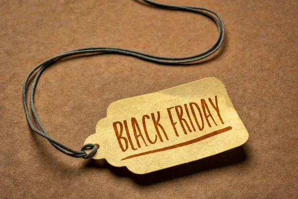 Black Friday sign - a paper price tag with a twine against texture paper, fall holidays and shopping concept