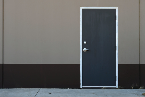 An image of a dark grey industrial metal exterior door.