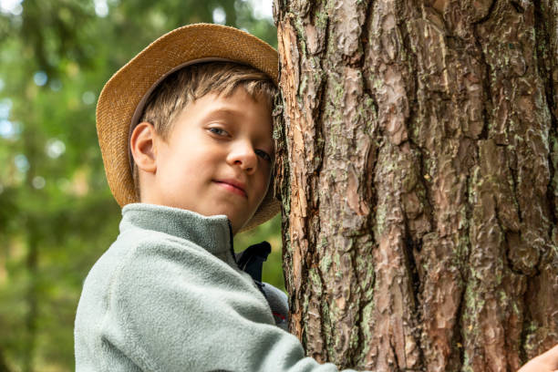 istock A happy Caucasian boy in a hat hugs a tree. outdoor walks 1432358950