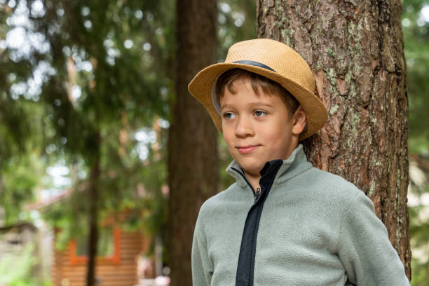 istock A happy Caucasian boy in a hat hugs a tree. outdoor walks 1432358952