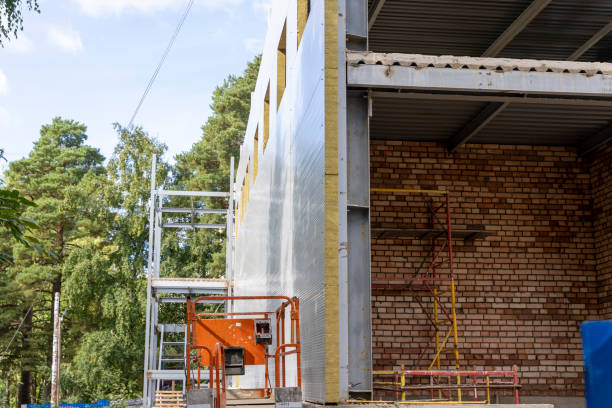 The metal frame of the new building with insulation and sandwich panels stock photo