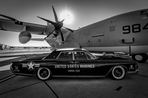 Miramar, California, USA - September 25, 2022: A 1969 Lincoln Continental and C-130 Hercules with the Marine Aerial Refueler Transport Squadron-352 static display at the 2022 Miramar Airshow.