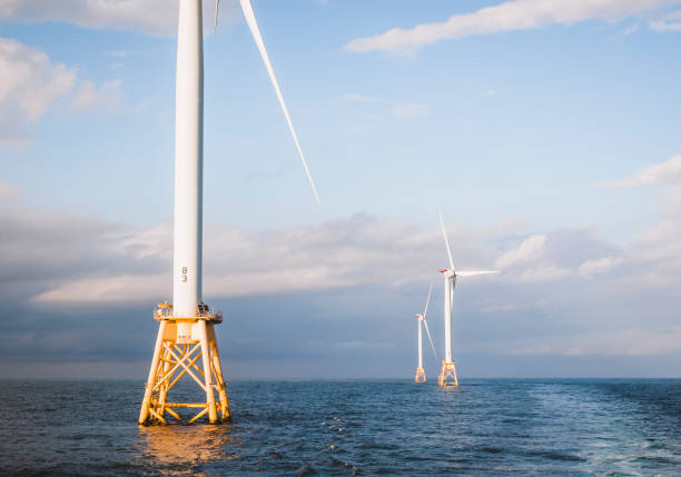 istock Three wind turbines at sunset in the middle of the ocean 1432360863