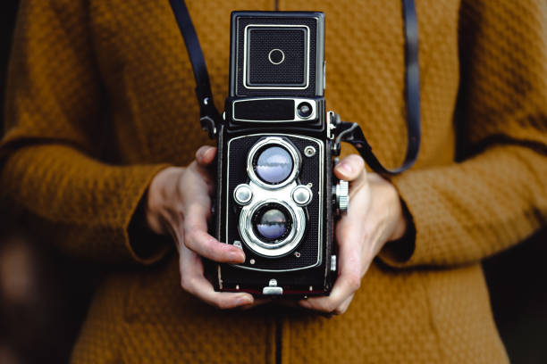 istock A young woman holds a retro 120 mm roll camera. 1432361360
