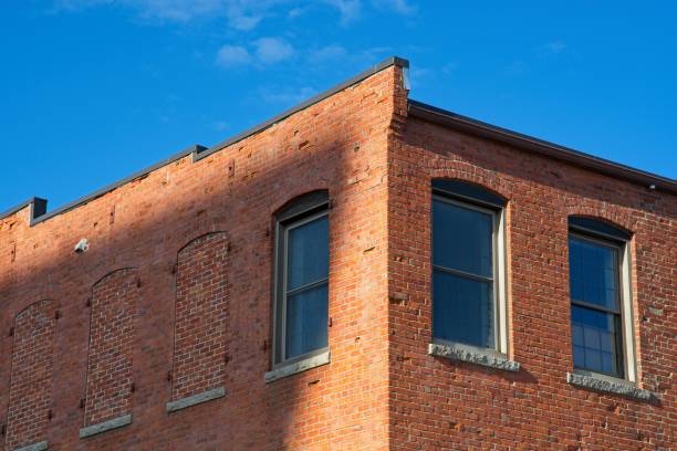 istock Brick mill building corner roofline against bright blue sky in Haverhill downtown 1432363220