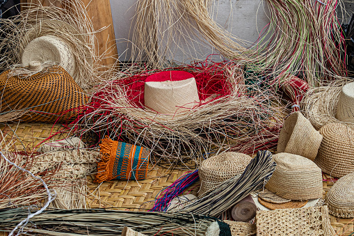 Big group of an authentic ecuadorian not finished Panama hats and paja toquilla straw used for weaving. Panama hats is popular souvenir from South America. Cuenca, Ecuador