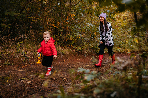 Little boy with his young mother during stroll in the forest