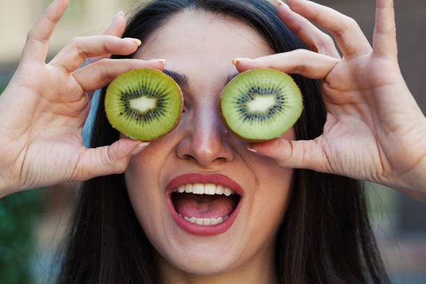 istock Young woman eating a kiwi 1432369274