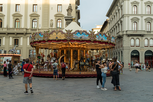 Locals and tourists enjoying a rid on a carousel in old town of Florence,Italy