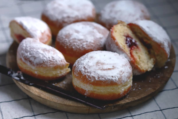 istock Berliner donuts in powdered sugar on a wooden tray. 1432374566