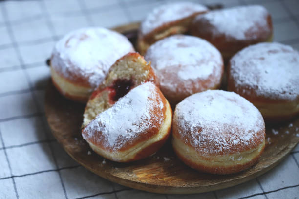 istock Berliner donuts in powdered sugar on a wooden tray. 1432374571