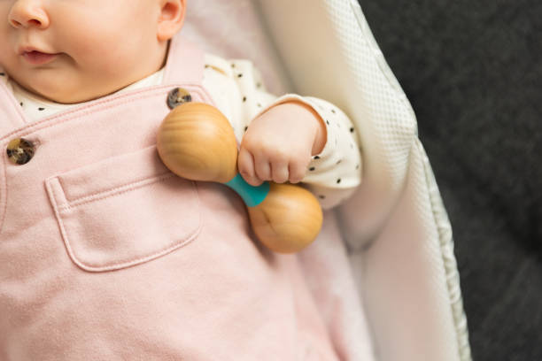 istock Baby holding a wooden rattle toy 1432374586