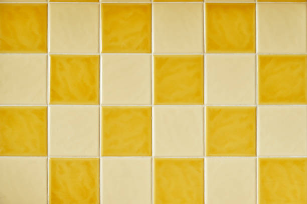 Orange and Yellow Kitchen Wall Tiles From The 1970s Original 1970s retro wall tiles. Square orange and yellow checkered tiles. Vintage style home decor. Colorful retro wall tiles with white grout showcase interior dining room home decorating home interior stock pictures, royalty-free photos & images