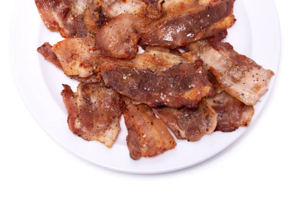 istock Cooked slices of bacon on white ceramic plate isolated on white background 1432377881