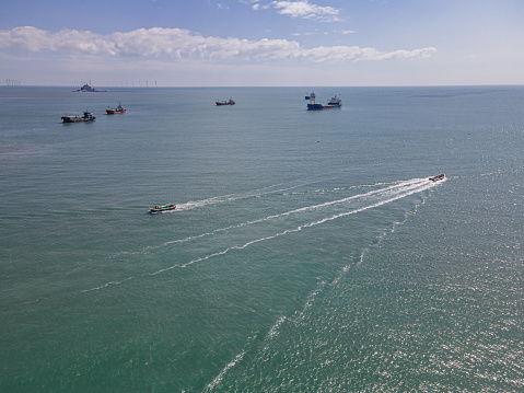 Two fishing boats are traveling opposite each other at sea